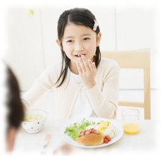 食事をしながらしゃべっている女の子