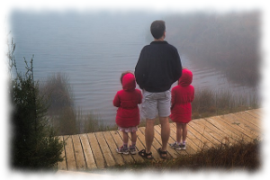 湖畔に佇む親子3人の画像
